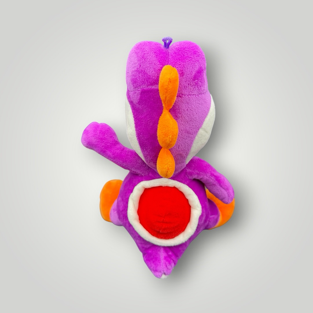 Die Bunte Box Gebrauchtwaren Lila Yoshi Plüschtier mit orangefarbenen Stacheln und rotem Bauch, weiches Spielzeug.