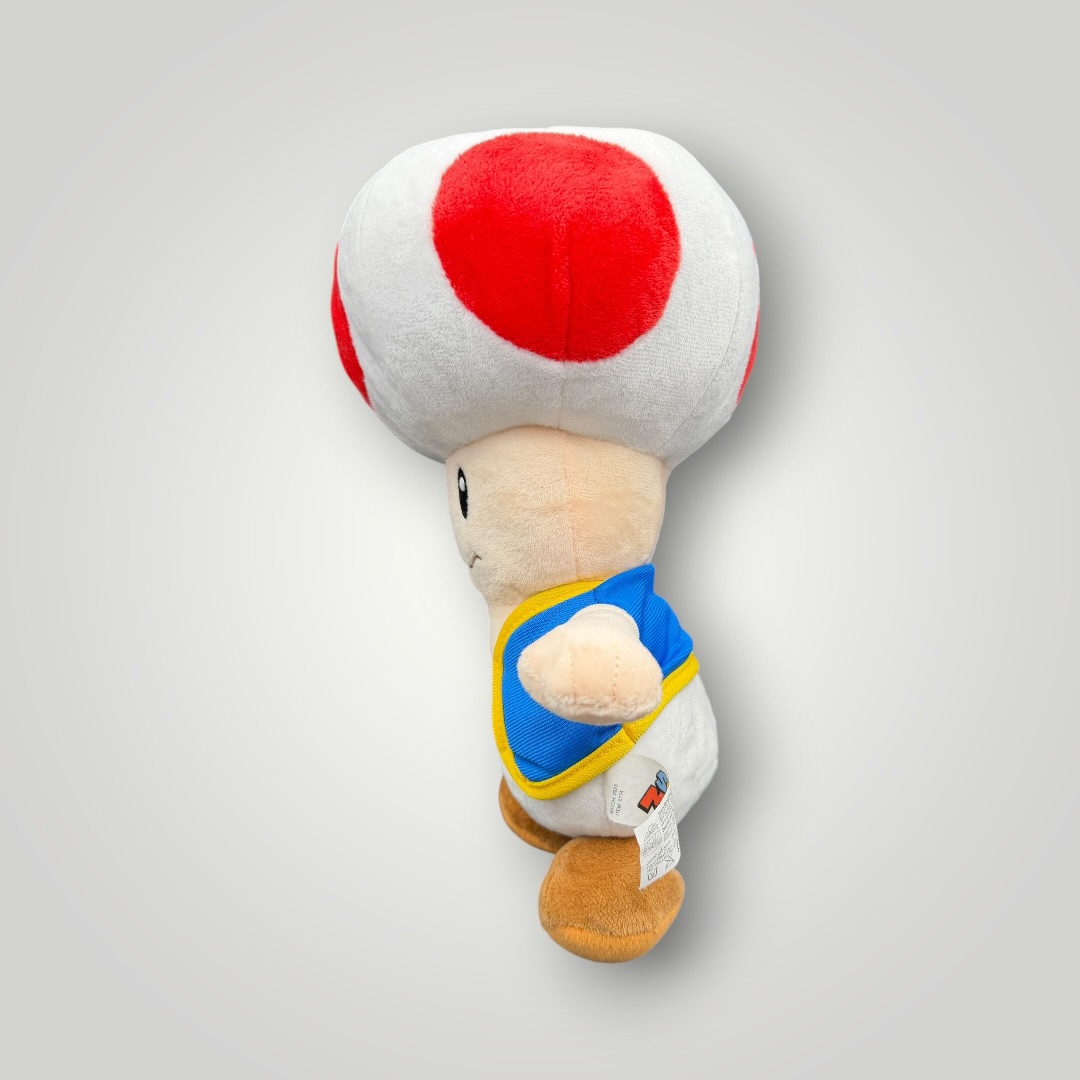 Die Bunte Box Gebrauchtwaren Super Mario Toad Plüschfigur mit rotem Pilzhut und blauer Weste, weiches Stofftier für Fans.